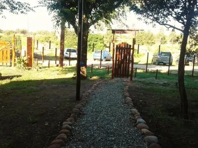 a path in a park with a gate and trees at Cabanas Junto al Rio in Panaholma