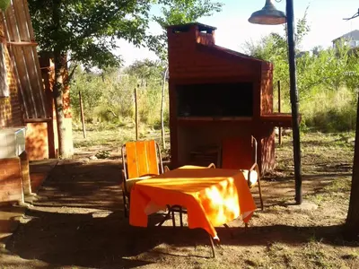 an orange table and chairs in front of a building at Cabanas Junto al Rio in Panaholma