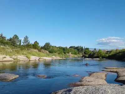 a person swimming in a river with rocks at Cabanas Junto al Rio in Panaholma
