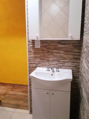 a bathroom with a white sink and a mirror at Cabanas Junto al Rio in Panaholma