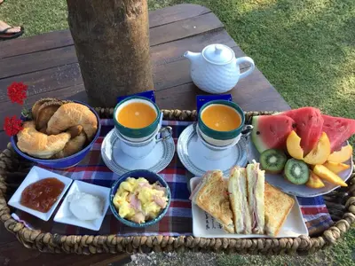a picnic table with a basket of food and two cups of coffee at Zolara Di Merlo in Merlo