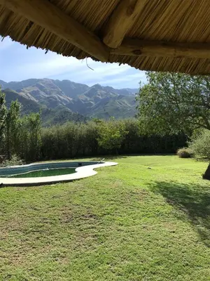 a swimming pool in a yard with mountains in the background at Zolara Di Merlo in Merlo