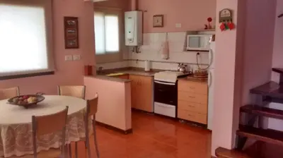 a kitchen with a table and a white refrigerator at Chalets Andalgala in Merlo