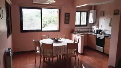 a kitchen with a table and chairs in a room at Chalets Andalgala in Merlo