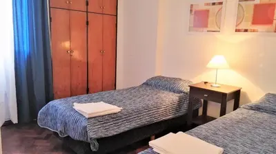 a bedroom with two beds and a table with a lamp at Céntrico, Confortable y Cómodo in Cordoba