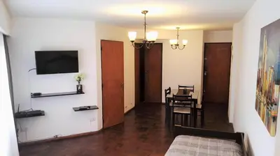 a living room with a television and a dining room at Céntrico, Confortable y Cómodo in Cordoba
