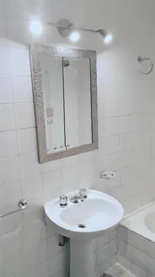 a white bathroom with a sink and a mirror at Céntrico, Confortable y Cómodo in Cordoba