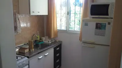 a small kitchen with a refrigerator and a microwave at Departamento Amarillis in Mina Clavero