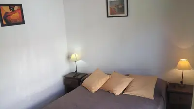 a bedroom with a bed with pillows and two lamps at Departamento Amarillis in Mina Clavero