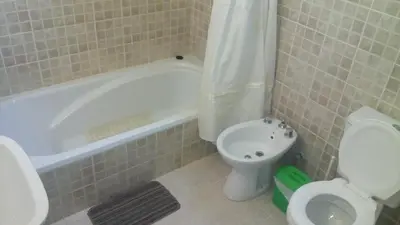 a bathroom with a tub and a toilet and a sink at Departamento Amarillis in Mina Clavero