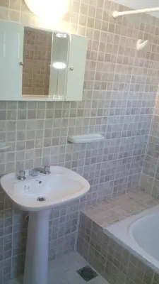 a bathroom with a sink and a tub and a mirror at Departamento Amarillis in Mina Clavero