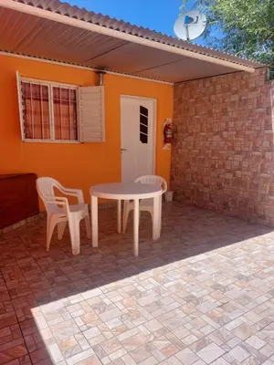 a patio with a table and chairs in front of a house at Departamentos La Familia in Mina Clavero