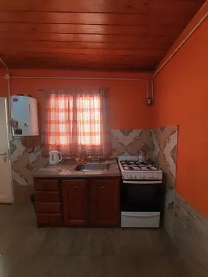 a kitchen with a stove and a sink and a window at Departamentos La Familia in Mina Clavero