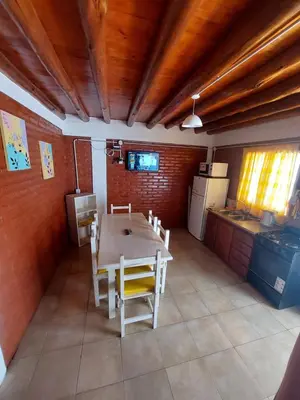 a kitchen with a table and chairs in a room at Departamentos La Familia in Mina Clavero