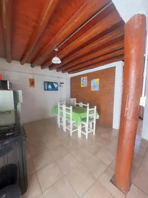 a kitchen with a table and chairs in a room at Departamentos La Familia in Mina Clavero
