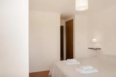 a white bedroom with two towels on a bed at Apartamento Obispo Trejo IV by Lofty in Cordoba