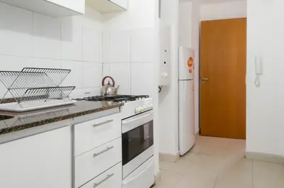 a white kitchen with a stove and a sink at Apartamento Obispo Trejo IV by Lofty in Cordoba