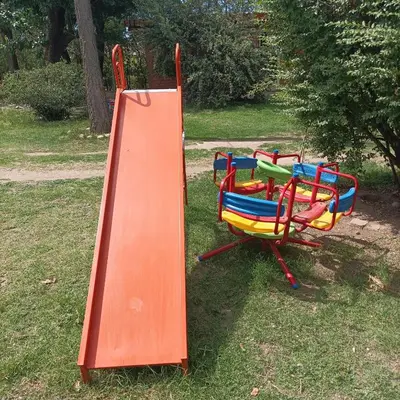 a set of colorful playground equipment sitting in the grass at El Chaparral Villa Dolores Traslasierra 2 in Piedra Pintada
