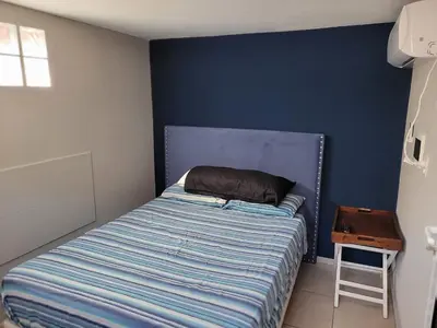a bed in a bedroom with a blue wall at Aqua Duplex in Villa Carlos Paz