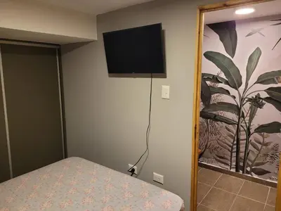 a bedroom with a bed and a flat screen tv on the wall at Aqua Duplex in Villa Carlos Paz