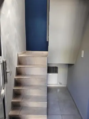 a staircase in a room with a blue wall at Aqua Duplex in Villa Carlos Paz