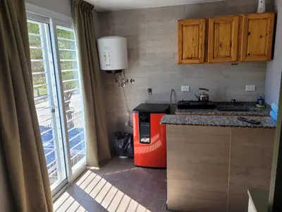 a kitchen with a stove and a red refrigerator at Aqua Duplex in Villa Carlos Paz