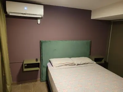 a small bedroom with a bed with a green headboard at Aqua Duplex in Villa Carlos Paz