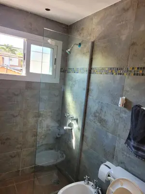a bathroom with a shower and a toilet and a sink at Aqua Duplex in Villa Carlos Paz