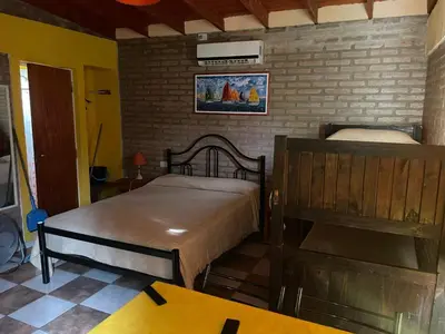 a bedroom with two beds and a brick wall at Altos del Mayu Cabañas - Alojamiento in San Antonio de Arredondo