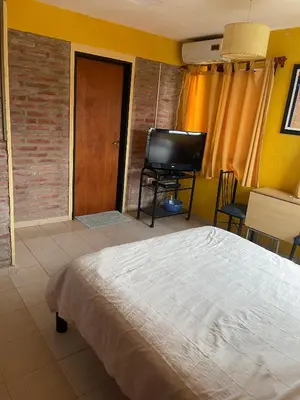 a bedroom with a bed and a flat screen tv at Altos del Mayu Cabañas - Alojamiento in San Antonio de Arredondo