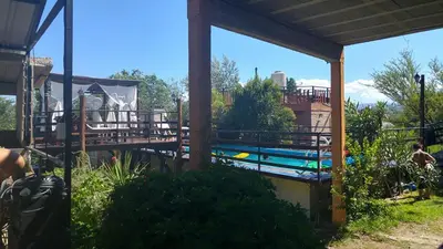 a swimming pool with a deck and a house at Altos del Mayu Cabañas - Alojamiento in San Antonio de Arredondo