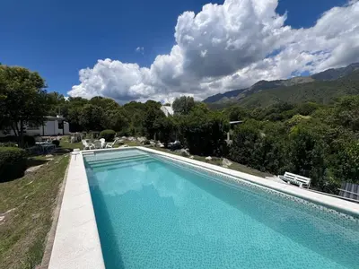 a swimming pool in a yard with mountains in the background at Casita siempre verde in Los Hornillos