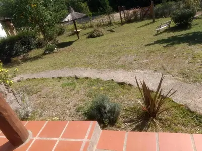 a garden with a bench and a grass field at Suricabanias in Villa Yacanto
