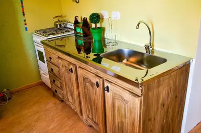 a kitchen counter with a sink and a stove at Suricabanias in Villa Yacanto