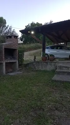 a dog sitting under a garage with a car parked at Suricabanias in Villa Yacanto