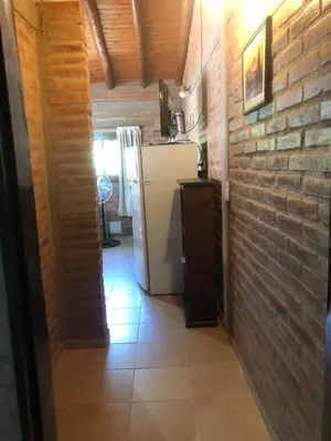 a kitchen with a refrigerator and a brick wall at Complejo La Morena in Mina Clavero