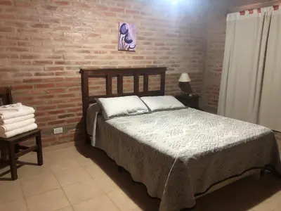 a bedroom with a bed and a brick wall at Complejo La Morena in Mina Clavero