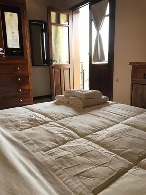 a large bed with towels on top of it at La Osadia Cabañas y Suites Solo Adultos in Mina Clavero
