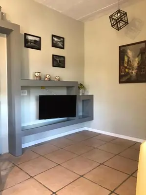 a living room with a flat screen tv on a wall at La Osadia Cabañas y Suites Solo Adultos in Mina Clavero