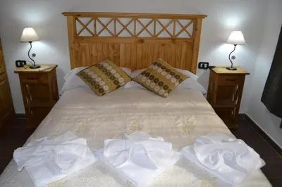 a bedroom with a bed with towels on it at Aguas Mornas Cabañas in Mina Clavero