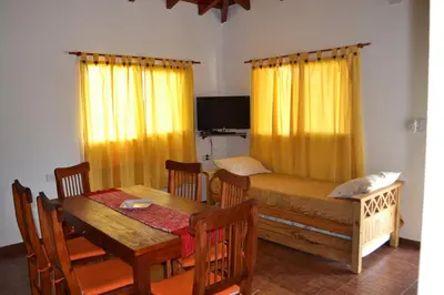 a room with a table and a bed and a dining room at Aguas Mornas Cabañas in Mina Clavero