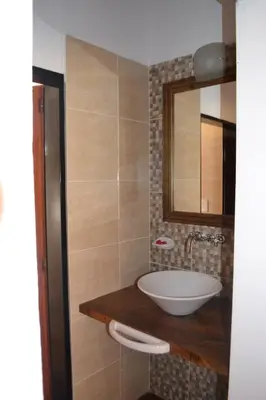 a bathroom with a sink and a mirror at Aguas Mornas Cabañas in Mina Clavero