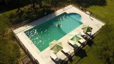an overhead view of a swimming pool with umbrellas at Complejo Sol Serrano in Mina Clavero