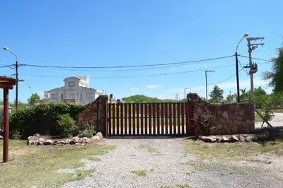 a wooden gate with a stone wall at Complejo Sol Serrano in Mina Clavero