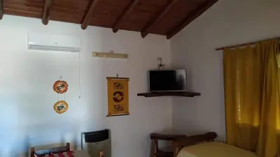 a room with a bed and a tv on the wall at Complejo Sol Serrano in Mina Clavero