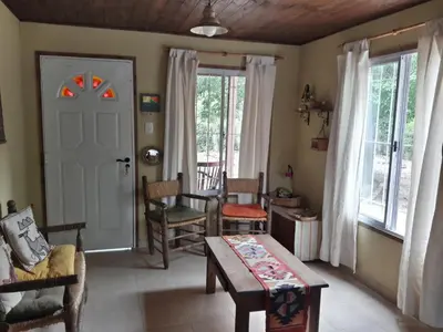 a living room with a table and chairs and a door at Cabañas de Campo in Santa María