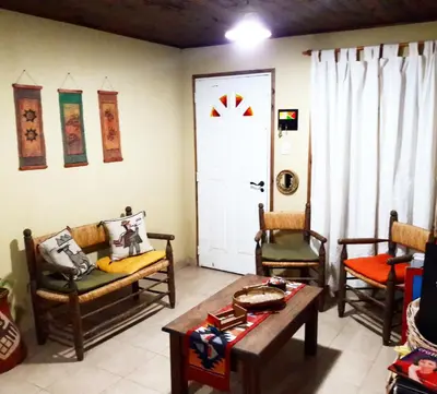 a living room with two chairs and a table at Cabañas de Campo in Santa María