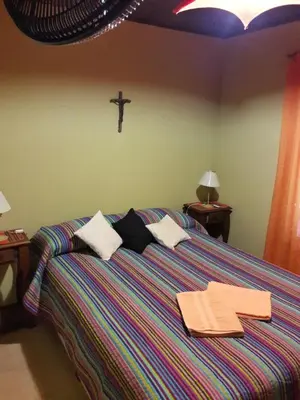 a bedroom with a bed with towels and a cross on the wall at Cabañas de Campo in Santa María