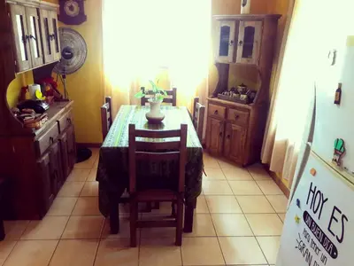 a kitchen with a table and chairs and a refrigerator at Cabañas de Campo in Santa María