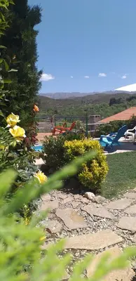 a garden with flowers and a playground in the background at Cerros Azules in Trapiche